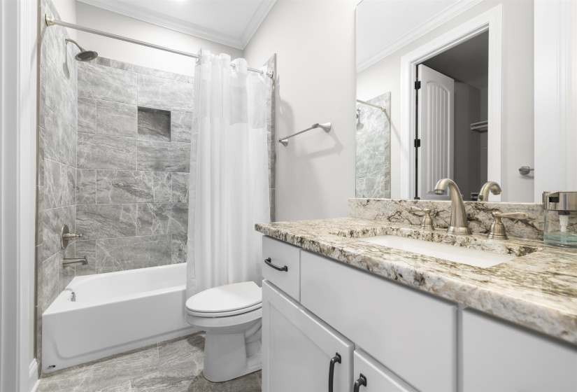 Bathroom featuring a white vanity with a granite countertop, undermount sink, and brushed nickel faucet