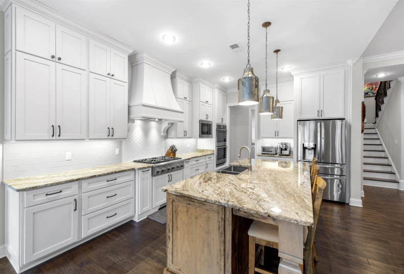 Gourmet kitchen featuring white shaker cabinetry, granite countertops, stainless steel appliances, a white subway tile backsplash, and dark wood-finish flooring