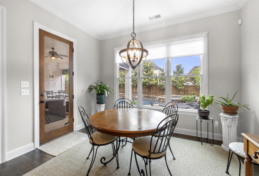 Dining area featuring dark wood-finish flooring, light grey walls, and white trim