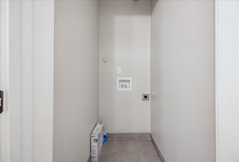Laundry area with hookup for a washing machine, electric dryer hookup, and light tile patterned flooring