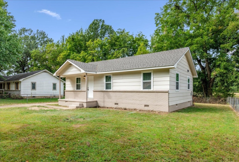 View of front of property featuring crawl space, a porch, roof with shingles, and brick siding