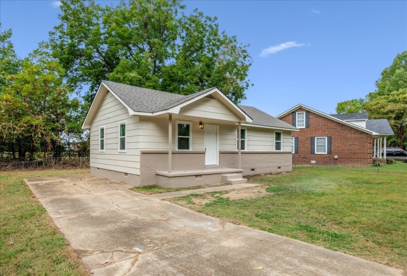 View of front of property with crawl space, covered porch, brick siding, and a shingled roof