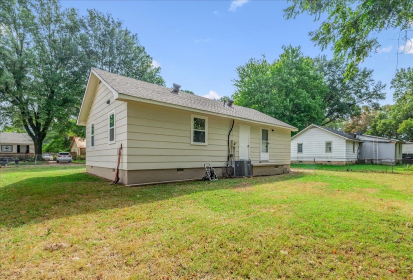 Back of house with crawl space and a shingled roof
