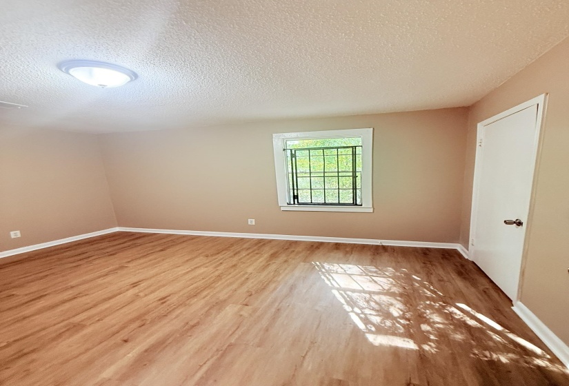 Unfurnished room featuring a textured ceiling and light wood-style flooring