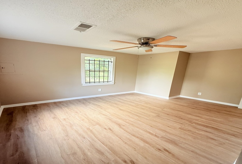 Unfurnished room featuring a textured ceiling, light wood-style flooring, and ceiling fan