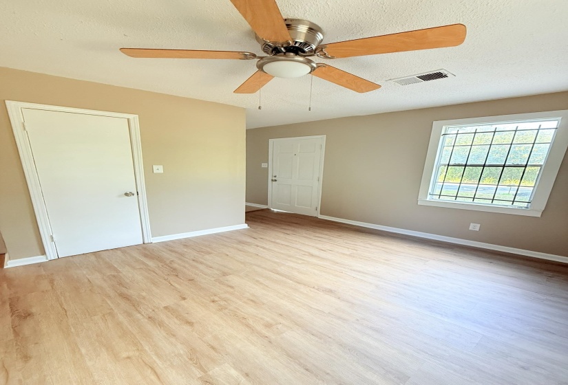 Unfurnished bedroom featuring a textured ceiling, light wood-type flooring, and a ceiling fan