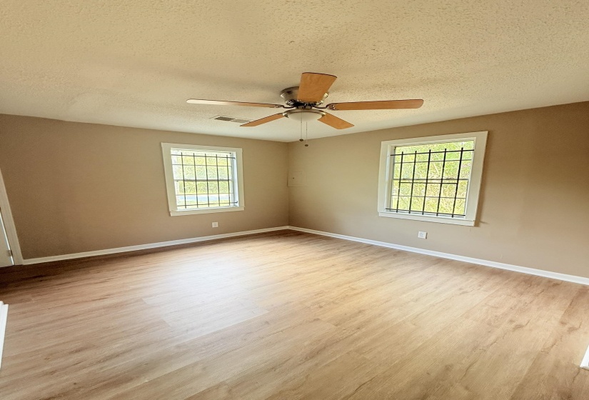Unfurnished room featuring a textured ceiling, light wood-style floors, and ceiling fan
