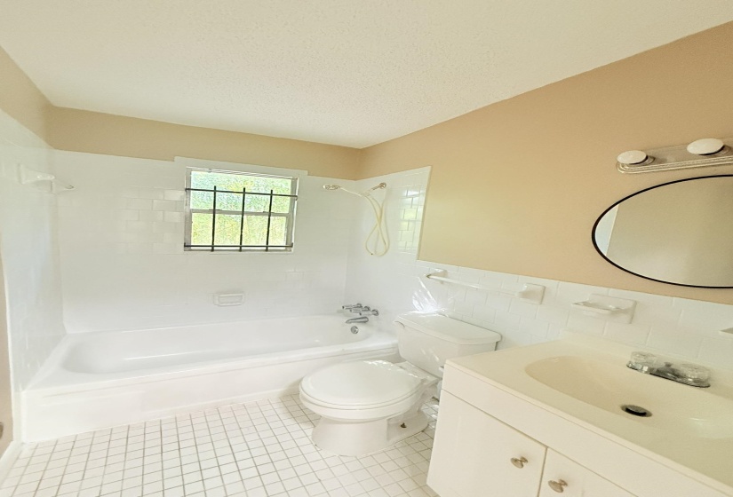 Full bath featuring shower / bathtub combination, vanity, light tile patterned floors, tile walls, and a textured ceiling