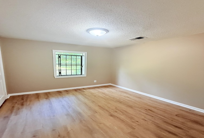 Spare room with a textured ceiling and light wood-style flooring