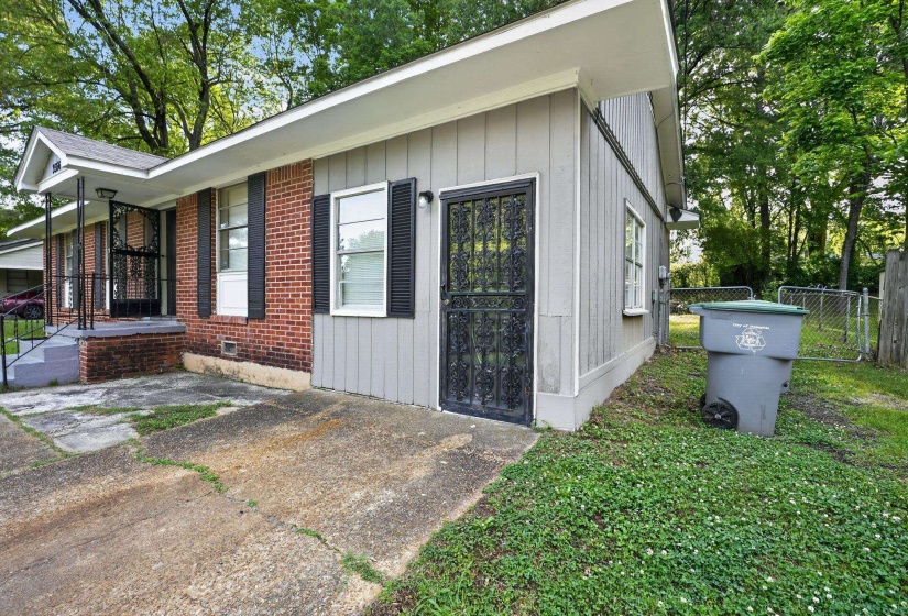 Brick and siding exterior featuring multiple windows with shutters and a covered porch with security screen door