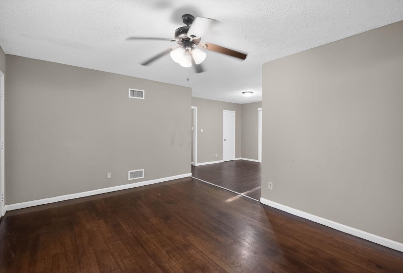 Spacious interior featuring dark wood-finish flooring, light gray wall paint, and white baseboards
