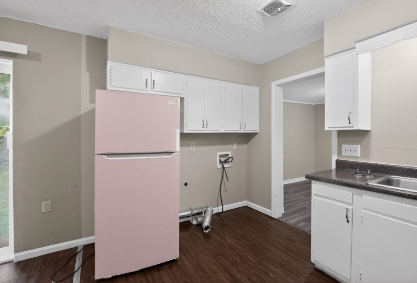 Kitchen area featuring dark wood-finish flooring and neutral wall tones