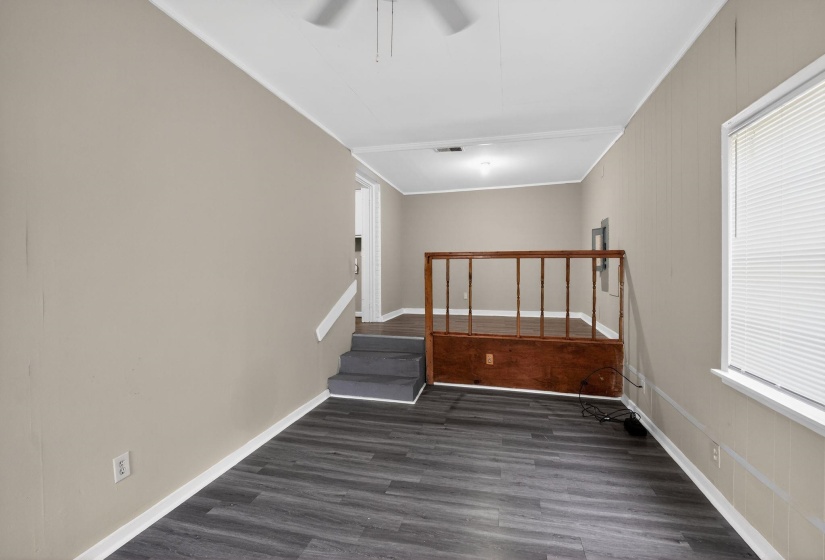 Open-concept room featuring wood-finish flooring, neutral wall paint, and white trim