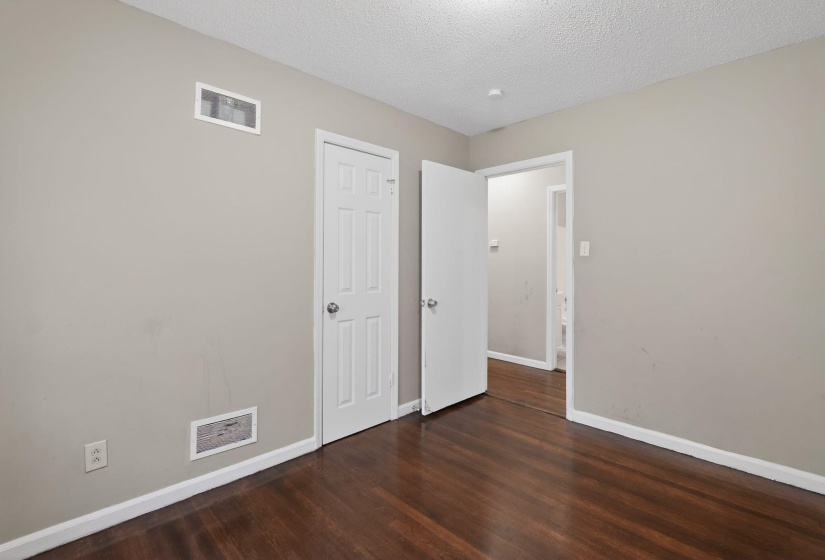Rich wood-finish flooring complements the neutral wall color