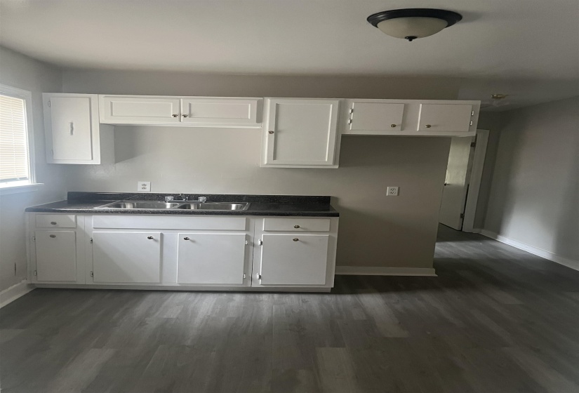 Kitchen featuring dark countertops, white cabinetry, and dark wood finished floors