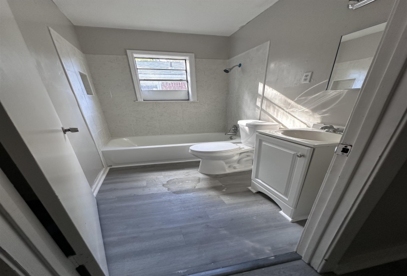Bathroom with vanity, shower / bathtub combination, and wood finished floors