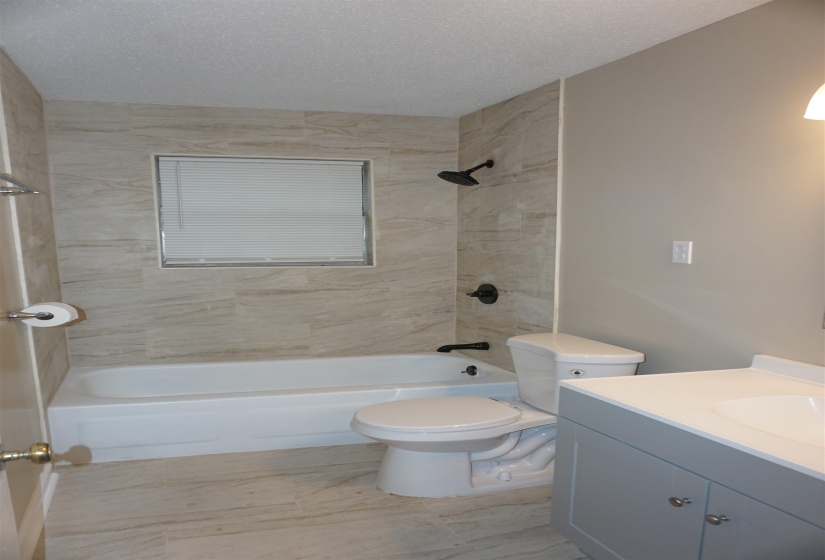 Bathroom featuring a single vanity with a white countertop and gray cabinetry