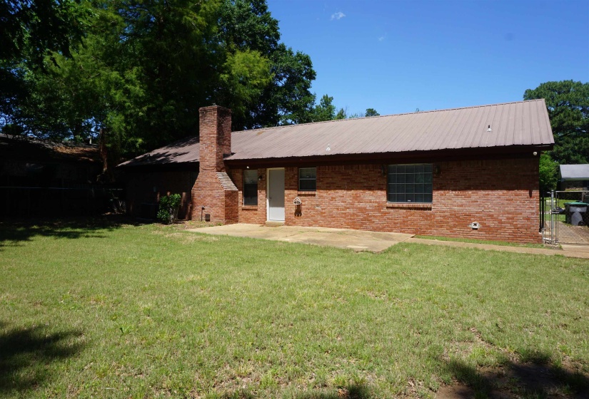 Brick exterior with a metal roof and a prominent brick chimney