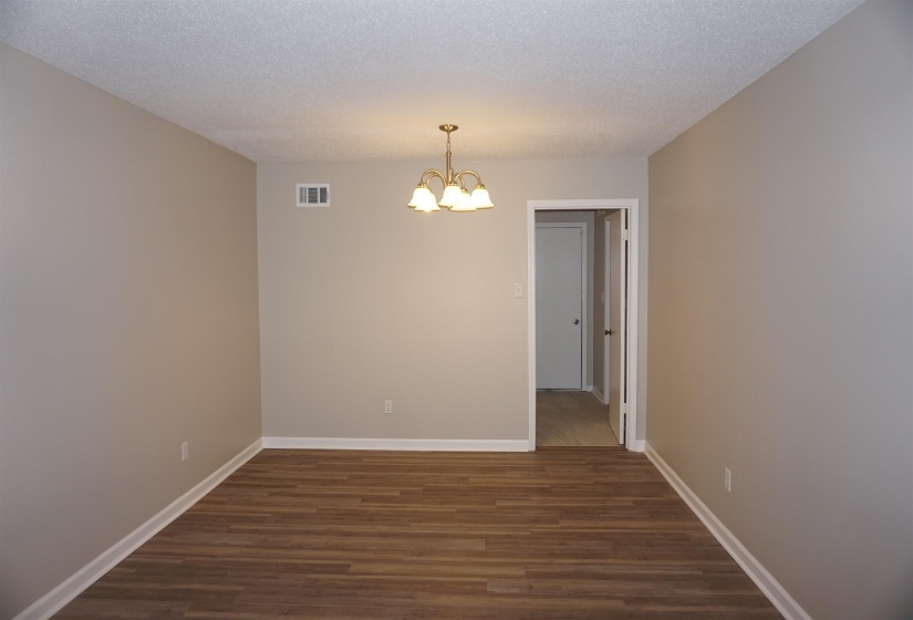 Open interior space featuring wood-finish flooring, neutral wall tones, and white baseboards