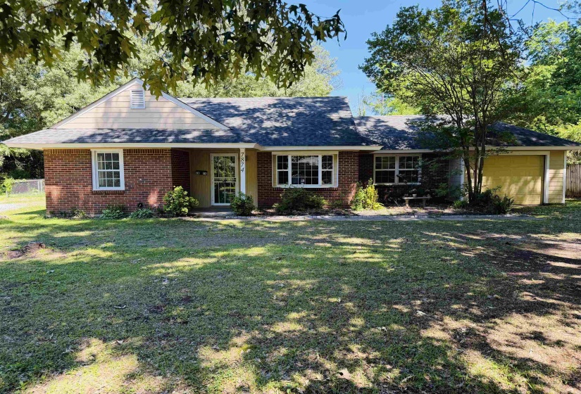 Brick and siding exterior featuring a prominent gable, white-framed windows, and a single-car garage