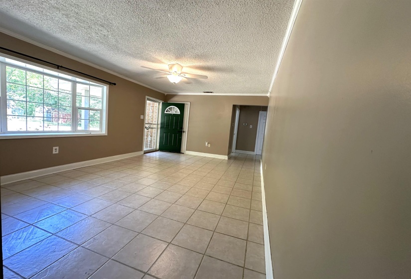 Spacious room featuring neutral wall tones, square tile flooring, and white baseboards
