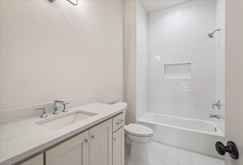Bathroom featuring a white subway tile shower surround with an integrated niche, a white soaking tub, and a vanity with a white countertop and undermount sink