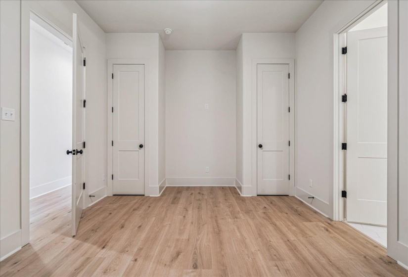 Interior space with wood-finish flooring, white walls, and white trim