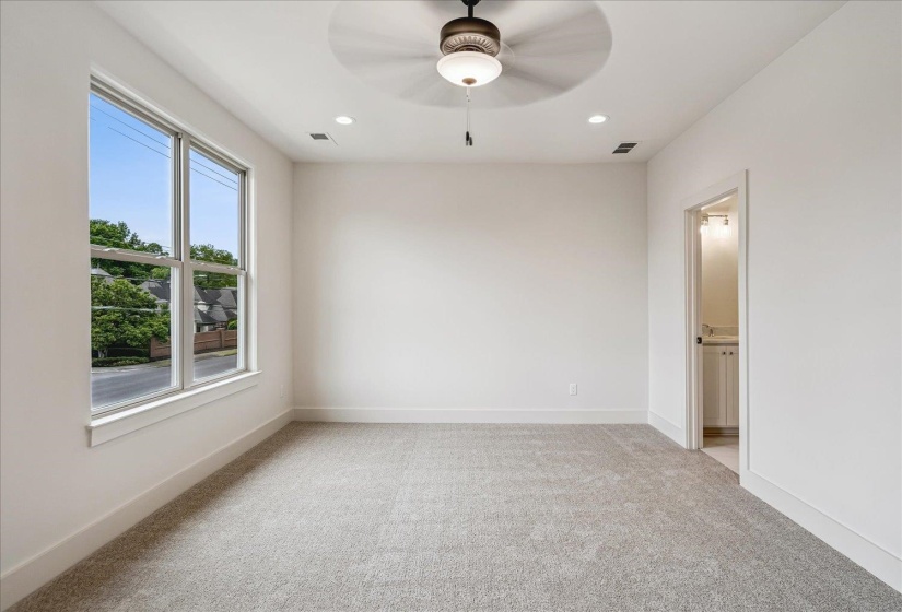 Spacious room featuring light gray carpeting, recessed lighting, and a ceiling fan