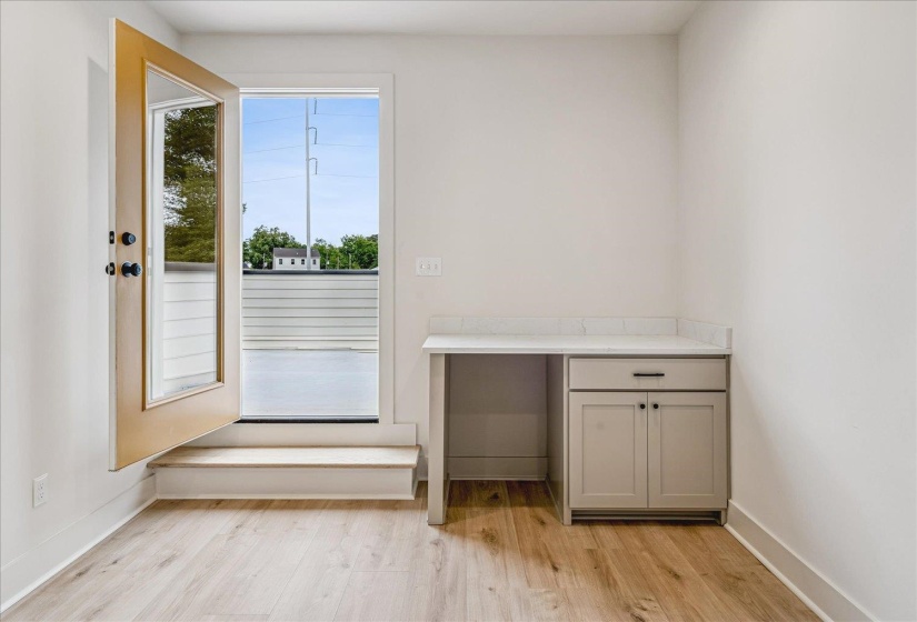 Light wood-finish flooring complements the neutral wall color