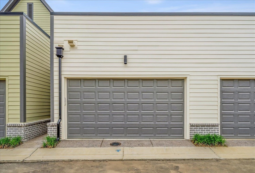 Exterior facade featuring light-colored horizontal siding and a large gray paneled garage door