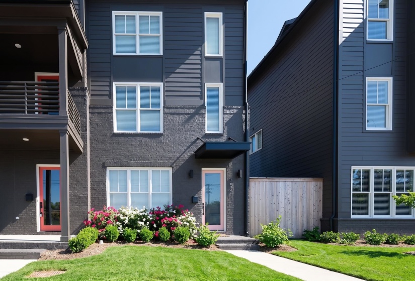 Contemporary facade featuring dark gray siding and brick accents