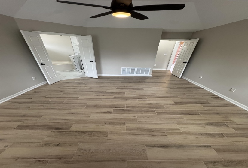 Unfurnished bedroom featuring wood tiled floors, a ceiling fan, and lofted ceiling