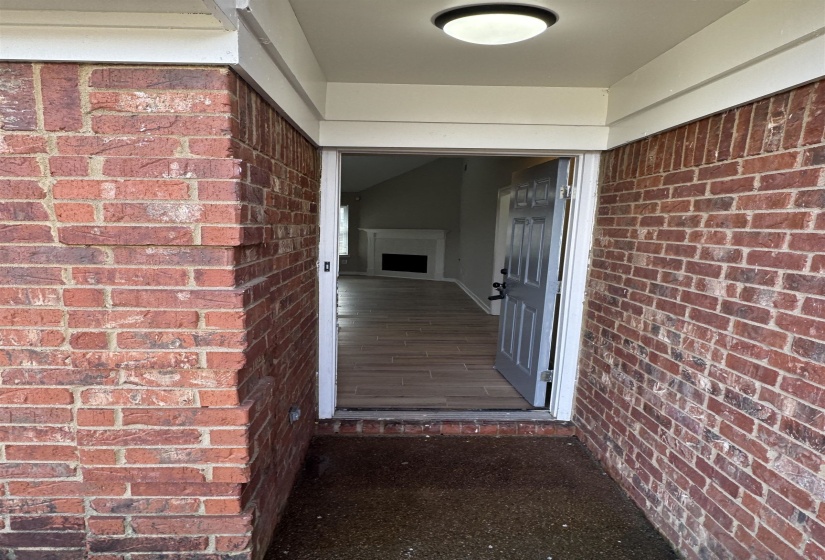 View of exterior entry featuring brick siding