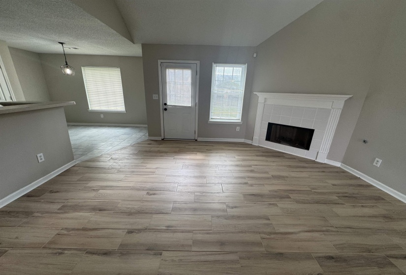 Unfurnished living room with a fireplace, light wood-style floors, and a textured ceiling