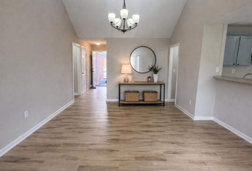 Unfurnished dining area featuring vaulted ceiling, light wood-style flooring, and suspended lighting
