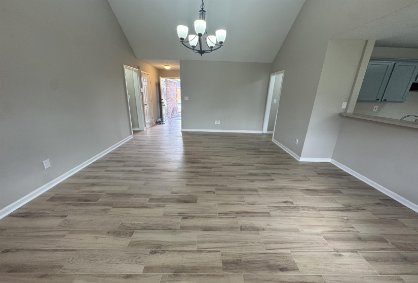 Unfurnished dining area with suspended lighting, vaulted ceiling, and light wood finished floors