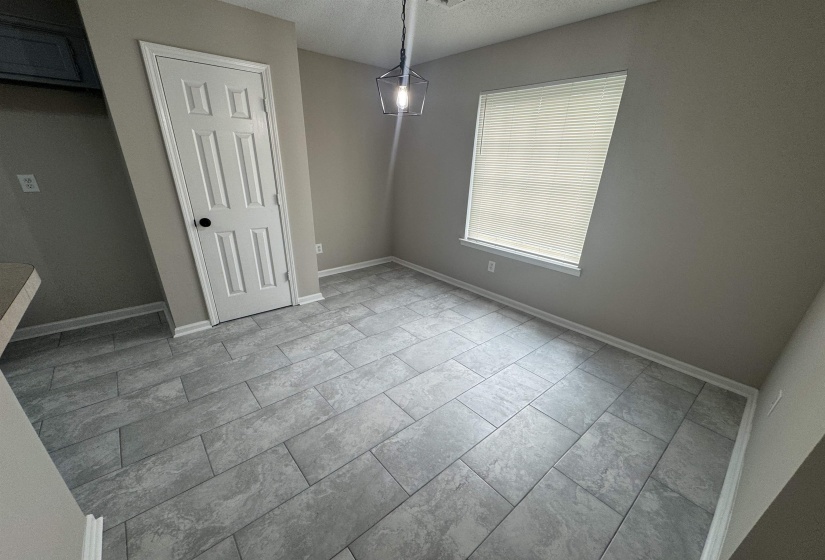 Unfurnished dining area featuring baseboards and a textured ceiling
