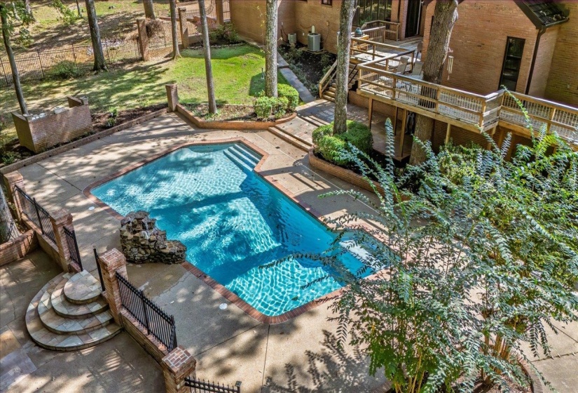 View of swimming pool featuring a wooden deck and stairs