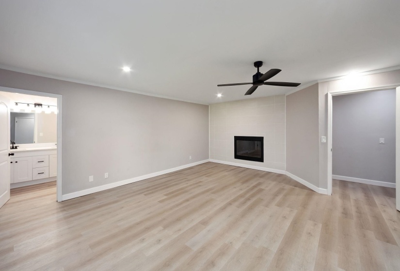 Spacious room featuring wood-finish flooring, recessed lighting, and a contemporary ceiling fan