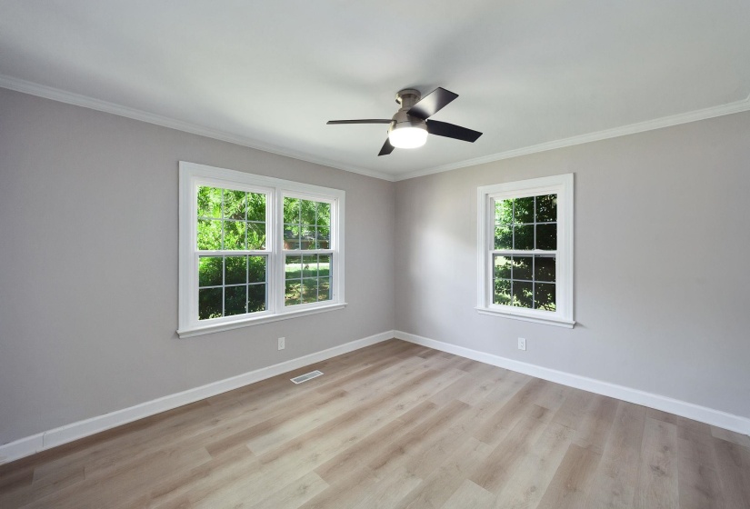 Bright interior with light wood-finish flooring, neutral gray walls, and white trim