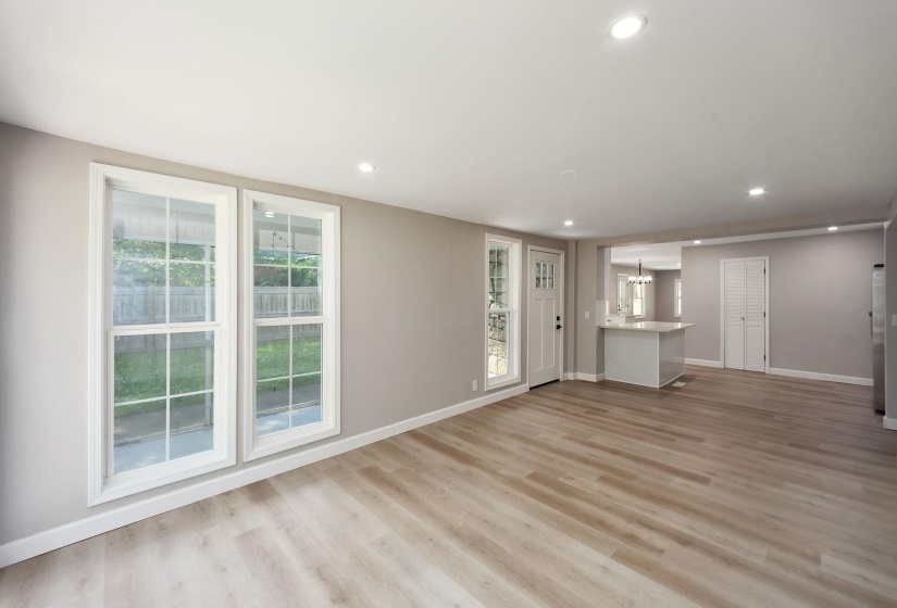 Open-concept living area featuring light wood-finish flooring, recessed lighting, and neutral wall tones