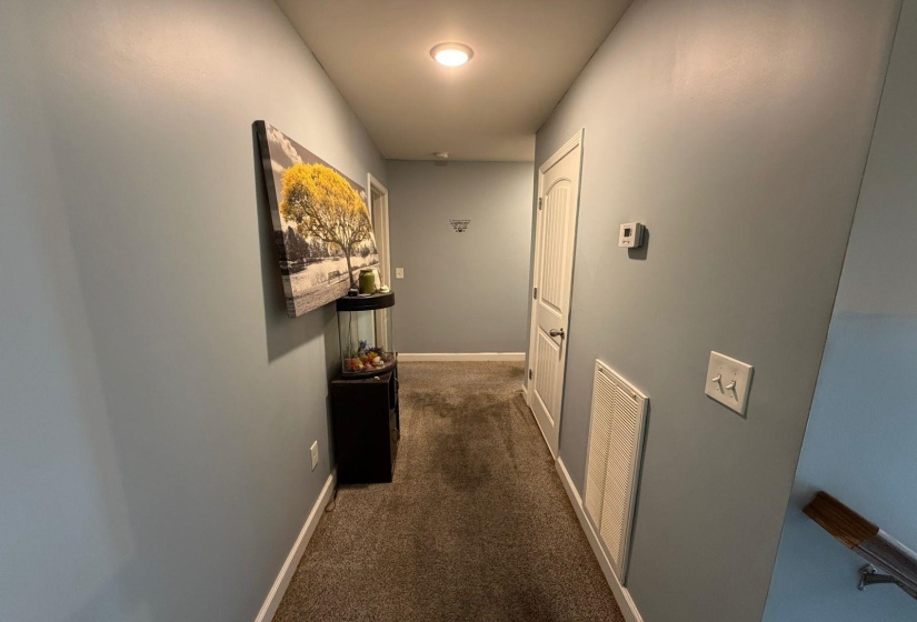 Hallway featuring light blue walls, brown carpeting, recessed lighting, and white trim
