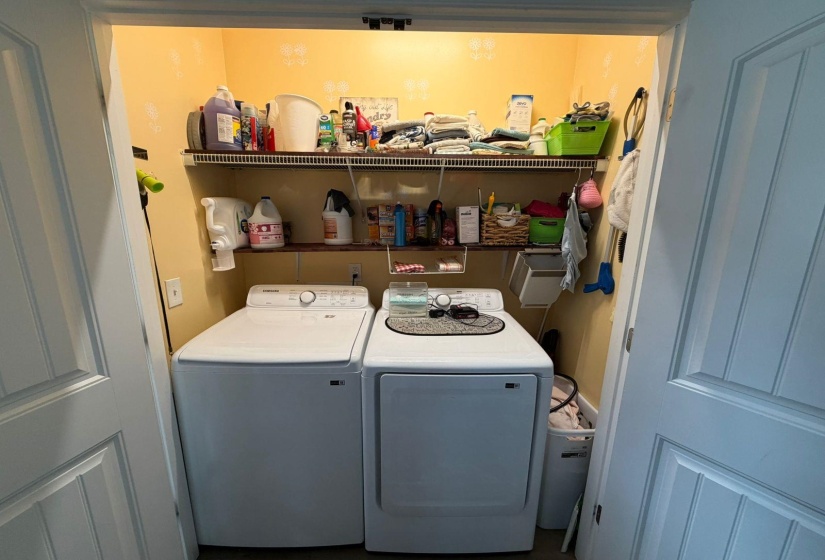 Dedicated laundry closet featuring a top-load washing machine and front-load dryer