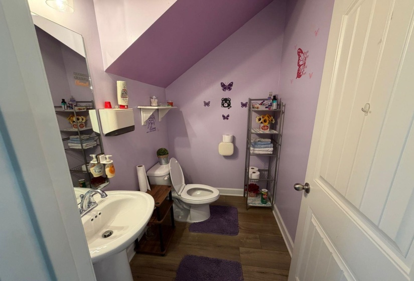 Pedestal sink with chrome faucet set against a purple wall