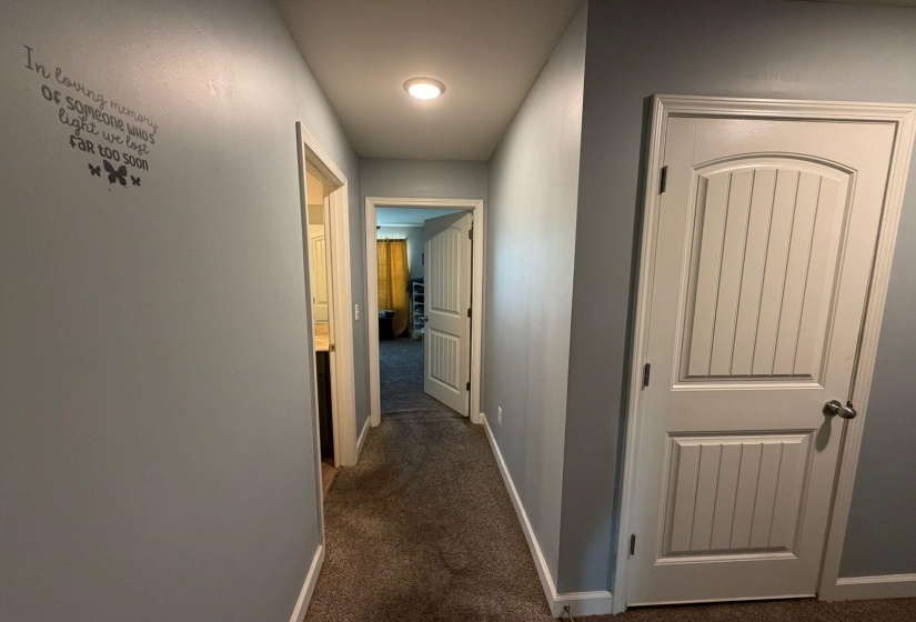 Hallway featuring light gray walls, white trim, and a recessed ceiling light