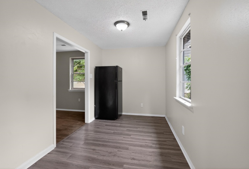 Spacious room with wood-finish flooring and neutral wall tones