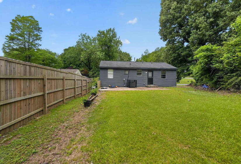 Expansive green lawn with a wood privacy fence