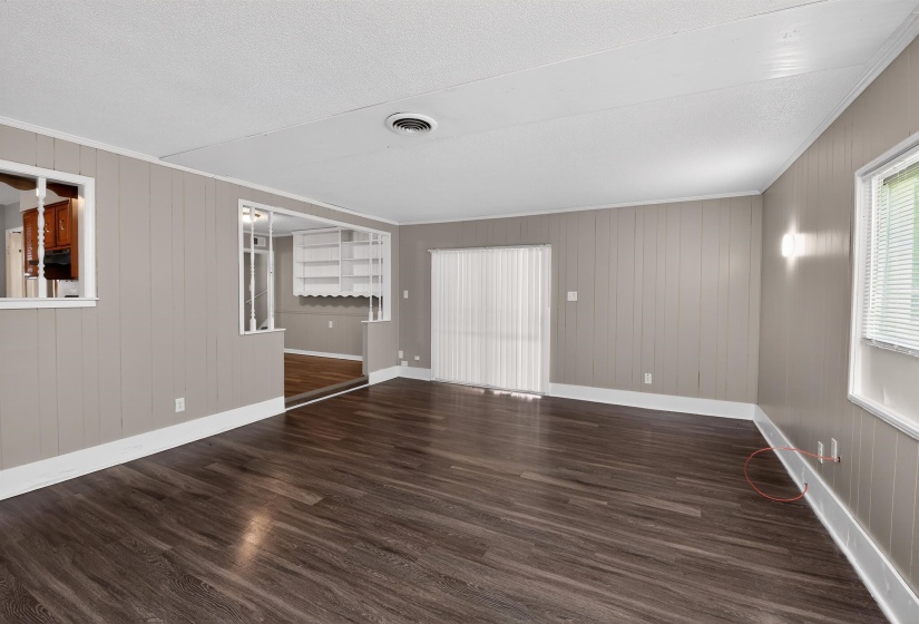 Spacious interior featuring wood-finish flooring, vertical paneling, and white trim
