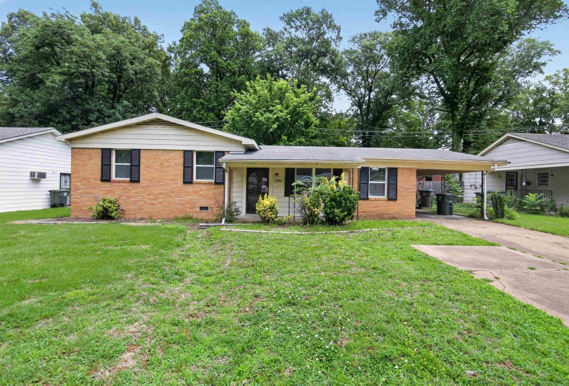 Brick and siding exterior with a partial carport