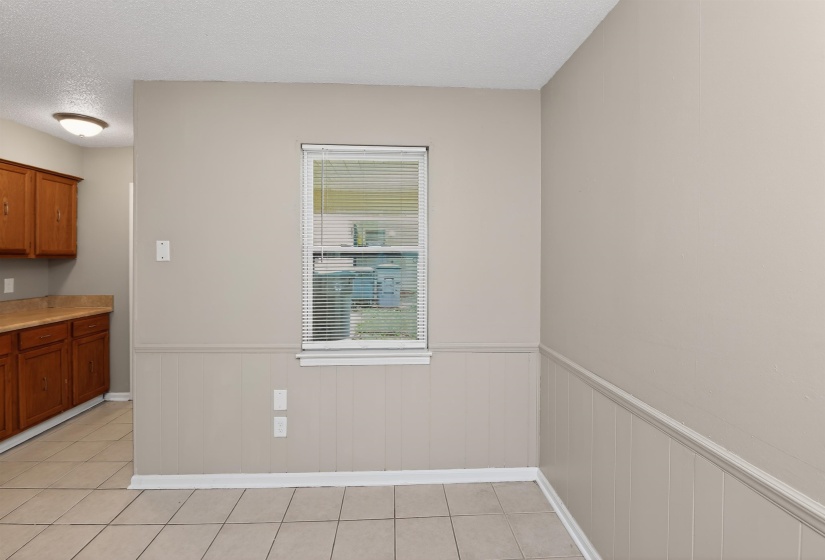 Neutral paint palette, tile flooring, and wainscoting details create a versatile interior